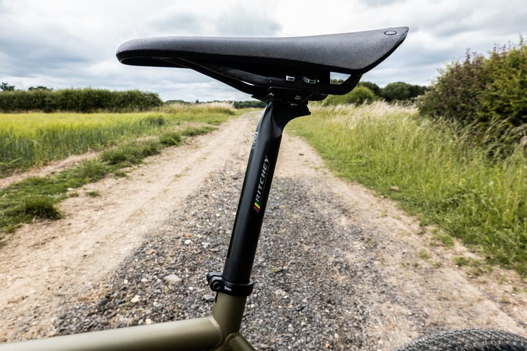 Ritchey WCS Carbon Link Flexlogic seatpost and Brooks Cambium C13 saddle on a gravel farm track.