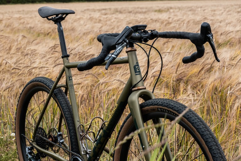 Bombtrack Hook EXT front end with SRAM Force levers and a Wahoo computer, set against a field of ripe crop.