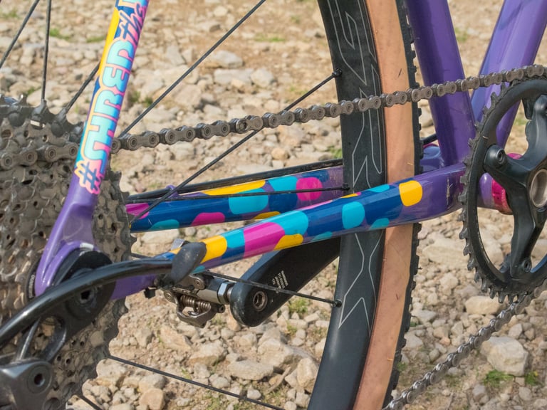 Close-up of the Mercredi's chainstay and seatstay, with Colourburn Studio's turquoise, yellow and pink spots on purple.
