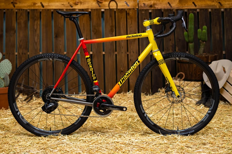 DeSalvo Gravel in a red, orange and yellow fade with checkerboard decals, built with SRAM Force and ENVE wheels.