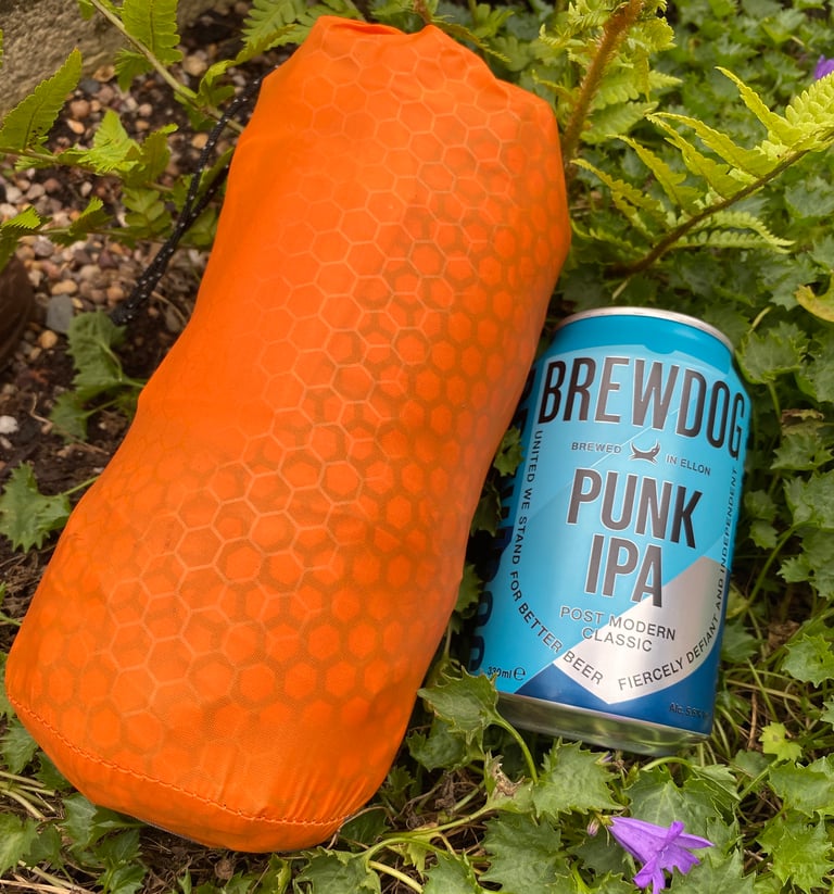 Exped SynMat HL M packed in its orange stuff sack beside a 330ml can of BrewDog Punk IPA for scale.