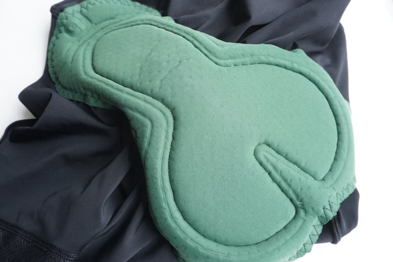 Green chamois pad sewn into the Alé Stones cargo bib shorts, laid out on a white surface.