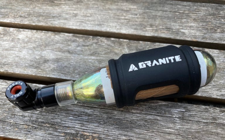 Granite PUNK CO2 inflator with Presta-only valve head and a cartridge in its black silicone sleeve.