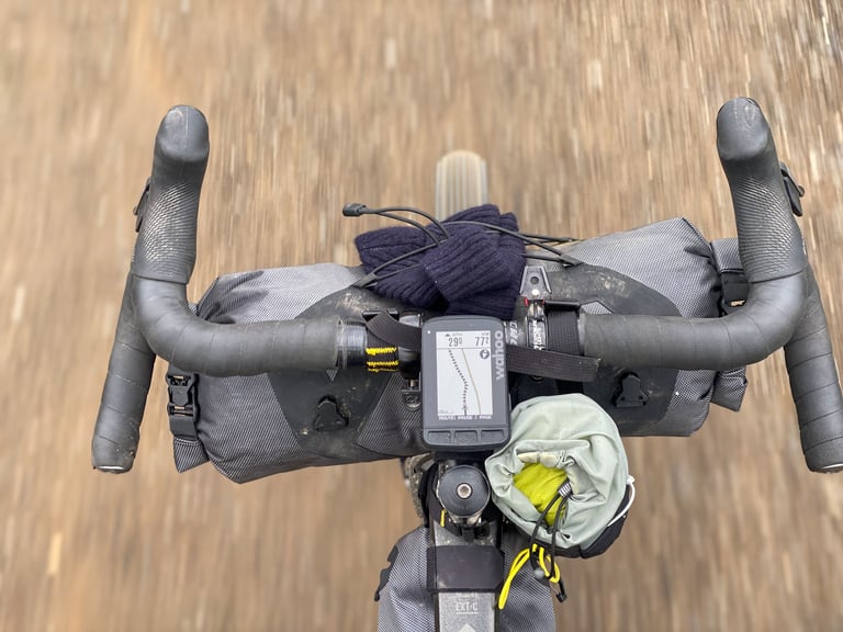 Handlebar view of the Bombtrack Hook EXT-C with Apidura bar pack and Wahoo ELEMENT ROAM showing the Iceland Divide route.