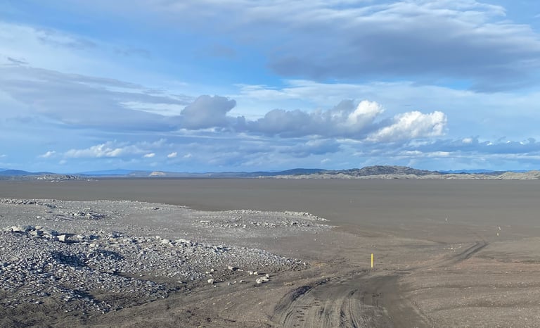 Vast empty volcanic plain with a single yellow marker post under a big sky on day three of the Iceland Divide.