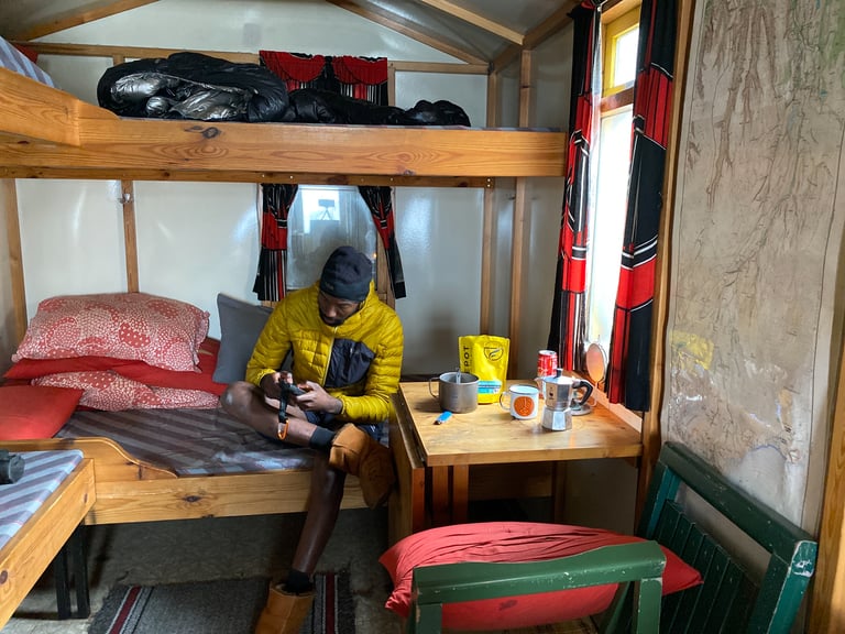 Natt Williams in Botni Mountain Hut with a Moka pot and coffee on the table before day two of the Iceland Divide.
