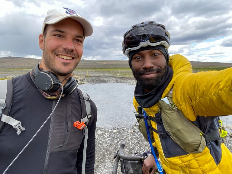 Natt Williams takes a selfie with German bikepacker Plaay beside a river crossing in the Icelandic Highlands.