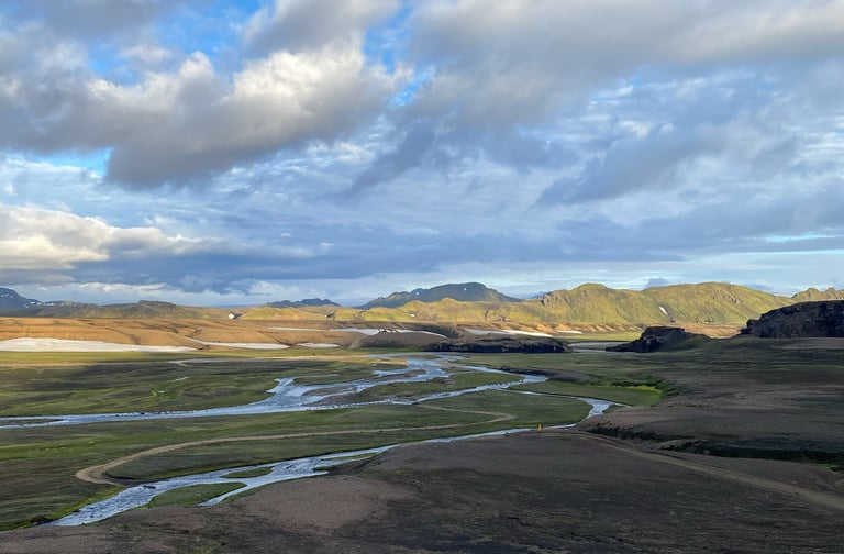 Braided glacial river threads across a green highland valley, one of many crossings on the Iceland Divide.