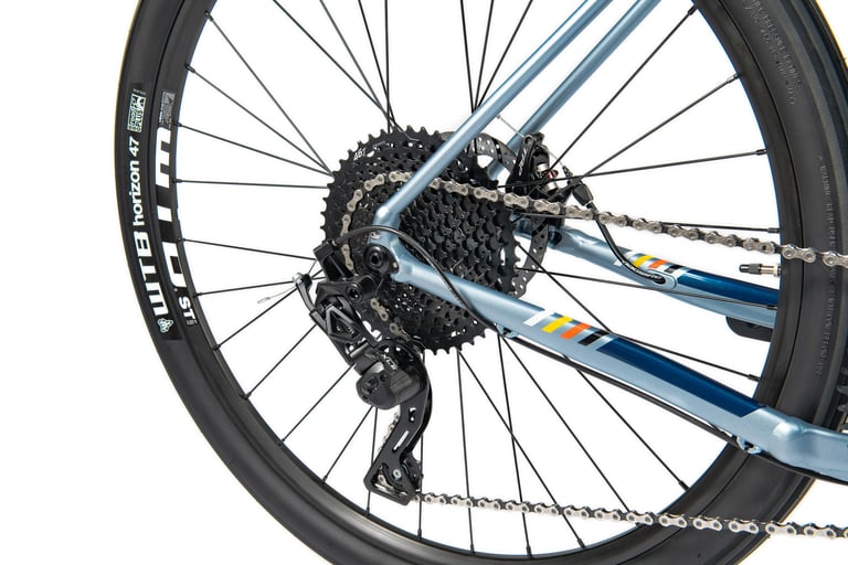 Microshift rear derailleur and wide-range cassette on the blue Bombtrack Audax AL, with a WTB Horizon 47 tyre.