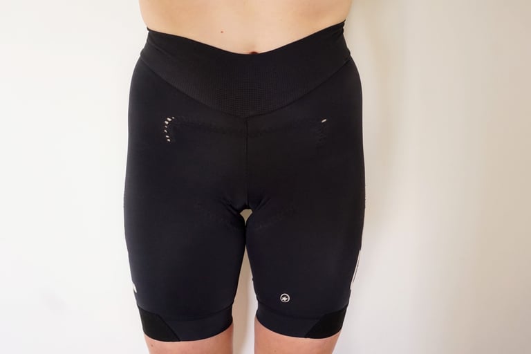 Worn black ASSOS road cycling shorts with a high waistband and holes, reused as an under-baggy layer.