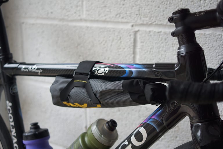 Apidura Downtube Pack strapped under the top tube of Katherine Moore's Colnago road bike, two bottles below.