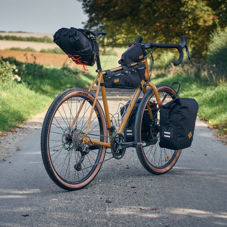 Ochre Fairlight Faran 2 with Restrap seat pack, frame bag and a front pannier, parked on a country lane.