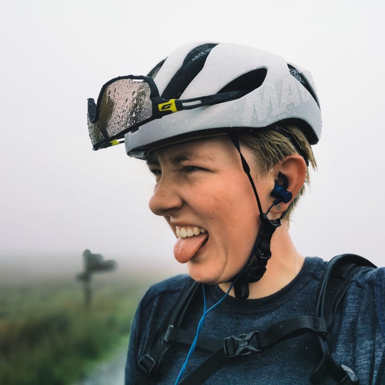 Molly Weaver sticks her tongue out, helmet and glasses beaded with rain, in thick mist during Unfinished Business.