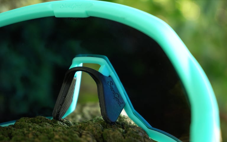 Inside view of the SunGod Velans glasses showing the black rubber nose pad on a mossy log.