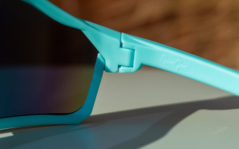 Close-up of the screw-free pop-lock hinge on the arm of the SunGod Velans glasses, with the SunGod name moulded in.