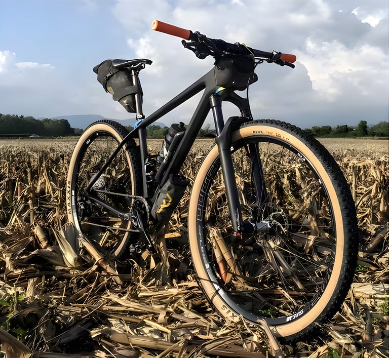 Rodney Soncco's mountain bike in a harvested field, with an Apidura Downtube Pack fitted to carry extra water.