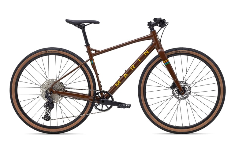 Marin DSX 2 in gloss brown with tan-wall WTB Riddler tyres, side view studio shot on white.