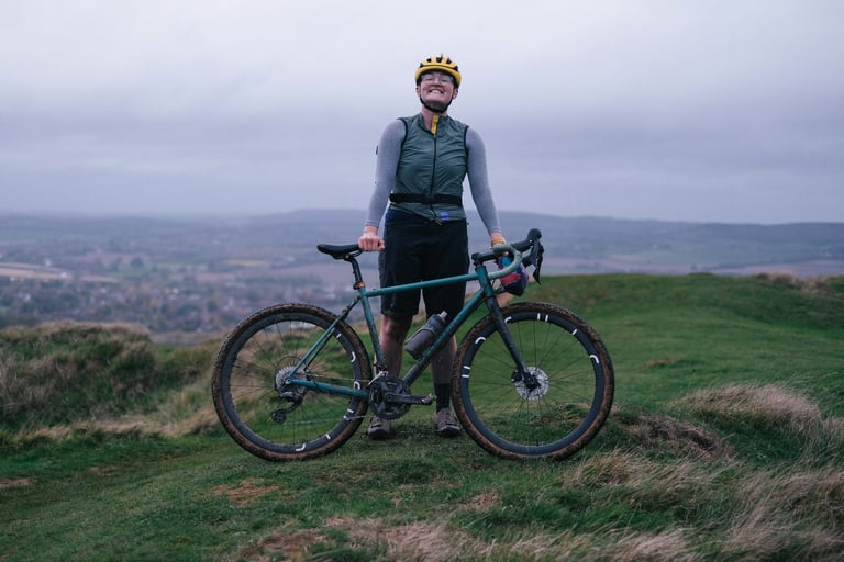 Grinning rider stands with the Stayer Groadinger UG on a grassy hilltop above the Kent countryside.