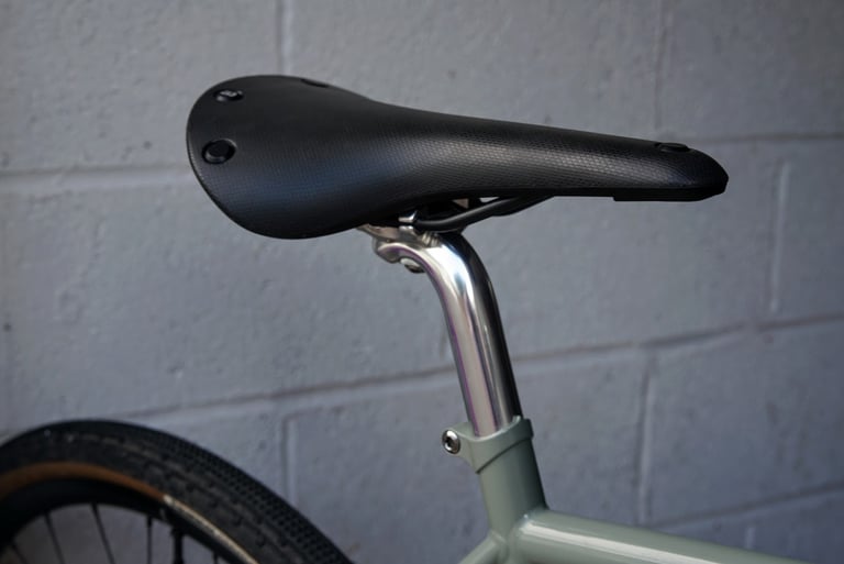 Black Brooks Cambium saddle on the polished alloy seatpost of the lichen green Temple Adventure Disc 1.