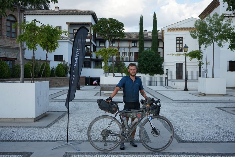 Marcus Nicolson stands with his loaded bikepacking bike after finishing the Badlands race in Granada.