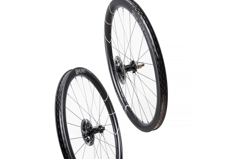 Front and rear Hunt 42 Limitless Gravel Disc wheels, deep carbon rims with disc rotors, on a white background.