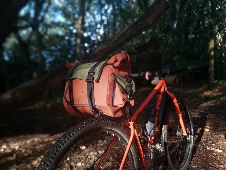 Shazam! saddle bag mounted on a Carradice Bagman Expedition support on an orange bike in dappled woodland light.