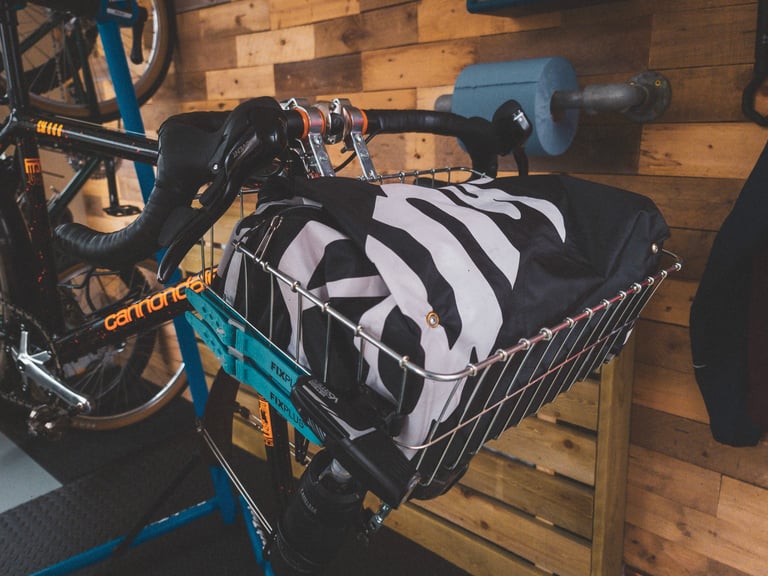 Wald 1392 basket on the Cannondale's drop bars holding a black-and-white bag sewn from a Campagnolo wheelbag.