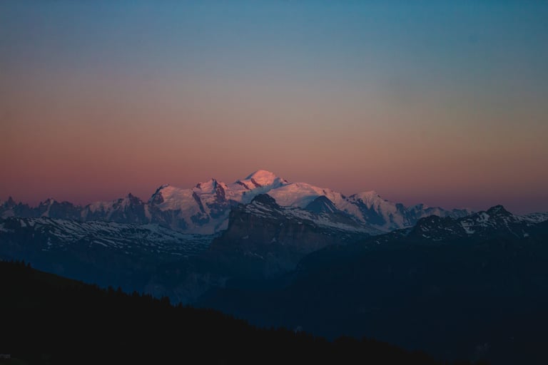 Mont Blanc's snowy summit glowing pink at sunset above dark ridges, from Samantha Saskia Dugon's print shop.