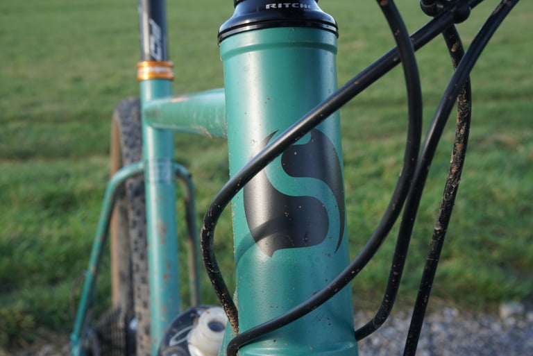 Stayer logo on the teal head tube of the Groadinger UG, spattered with mud, with a Ritchey headset above.