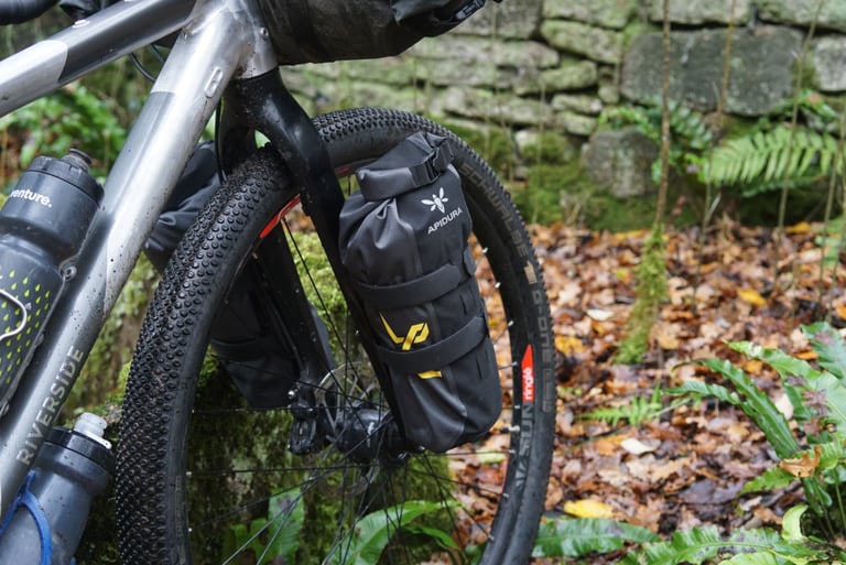 Apidura fork pack strapped to a leg of the Riverside 920 carbon fork, beside a Schwalbe tyre.