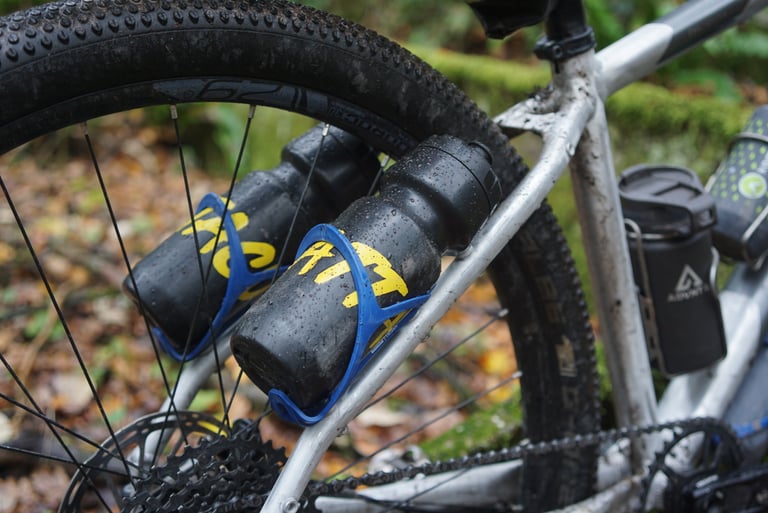 Two bottles in blue cages mounted on the seat stays of the Riverside 920 prototype, beside the rear wheel.