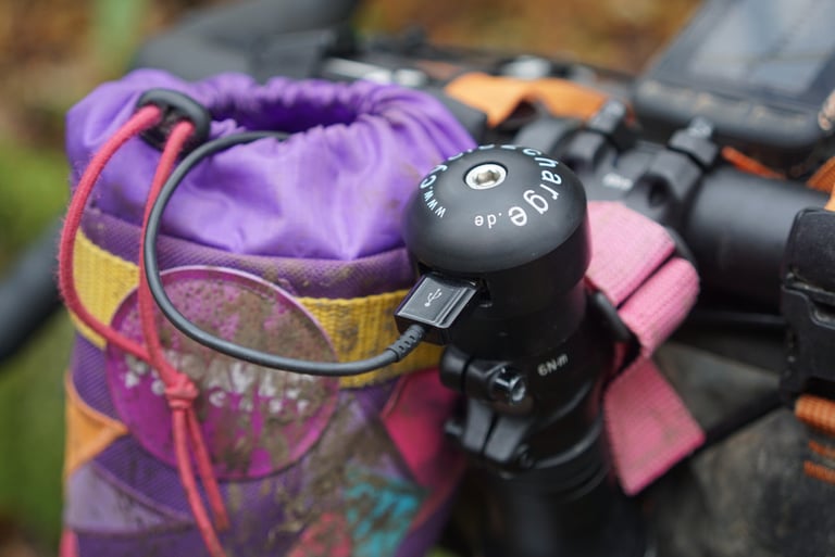 Cycle2Charge USB port on the steerer of the Riverside 920, with a cable plugged in beside a stem pouch.