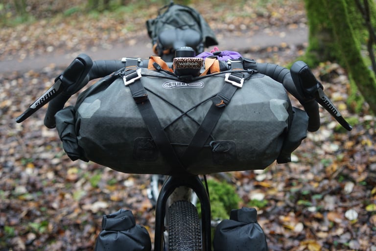 Ortlieb handlebar bag strapped between the wide flared bars of the Riverside 920, with SRAM levers either side.