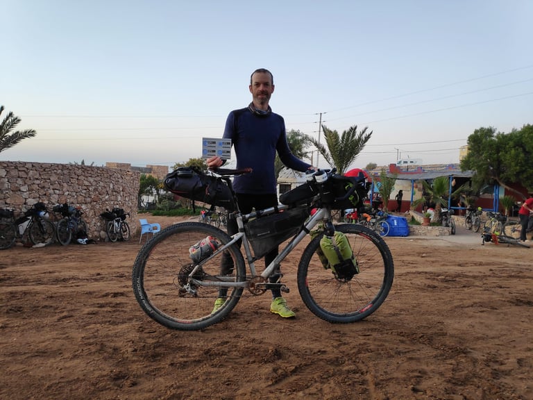 Pierre Gouyou Beauchamps stands behind a loaded Riverside 920 prototype at the finish of the first Atlas Mountain Race.