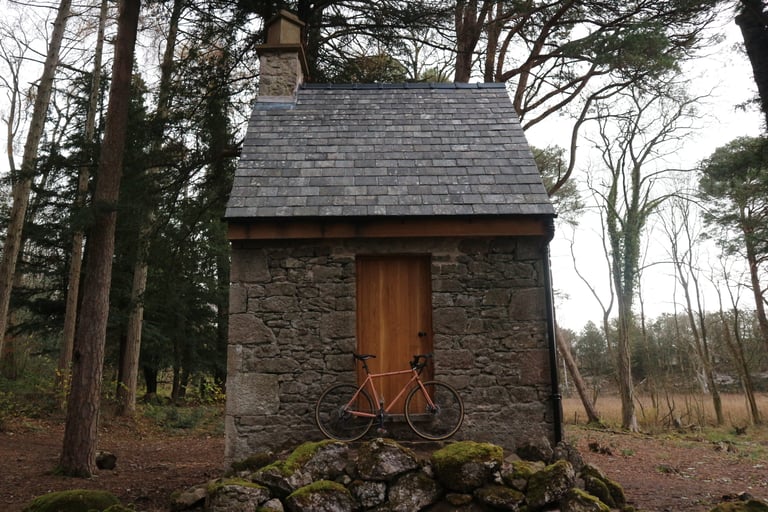 Pink Genesis Croix de Fer propped against the wooden door of the slate-roofed stone summerhouse at Gaits Barrow.