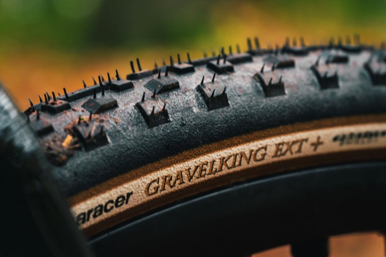 Close-up of a new Panaracer GravelKing EXT Plus tyre with tan sidewall lettering and square shoulder knobs.