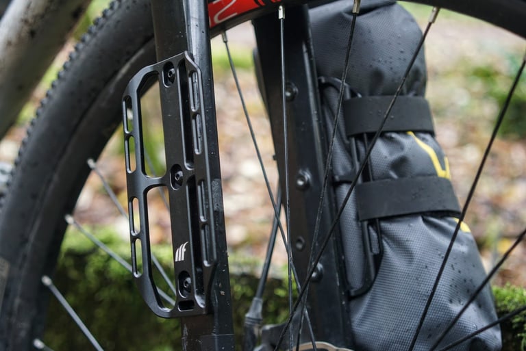 Tailfin Cargo Cage bolted to the fork of a Riverside 920 on test, with a strapped fork bag on the other leg.