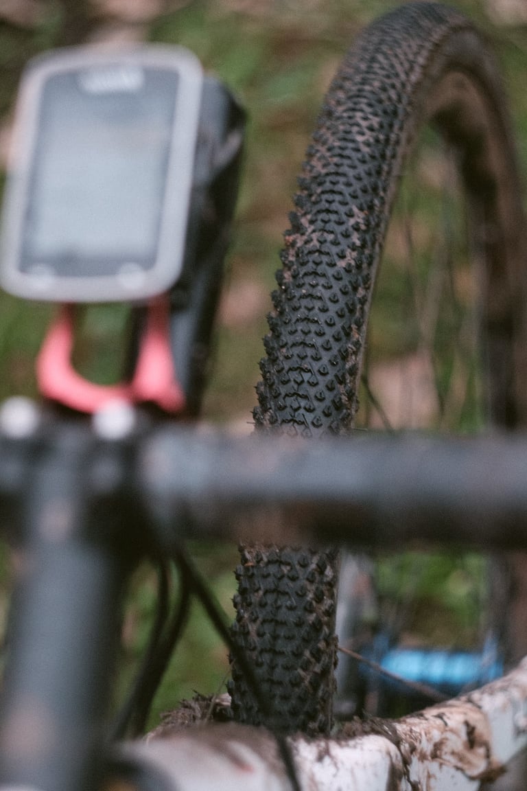 Diamond-shaped knobs of a Halo GXC gravel tyre, seen from the handlebars past a bike computer.