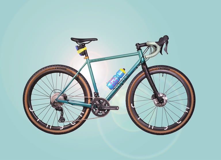 Stayer Groadinger UG in teal, side view, with Teravail tyres, a spotted bottle and yellow strap on a pale blue backdrop.