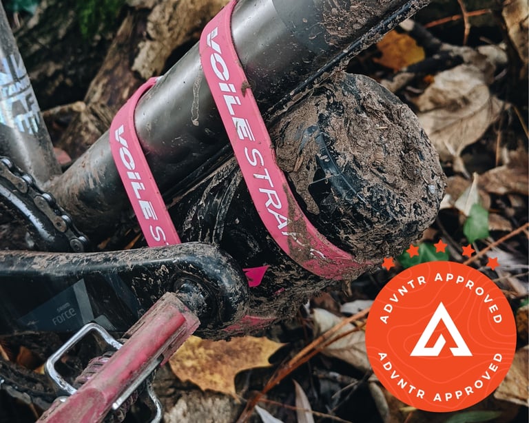 Pink Voile straps holding a mud-caked canister to a bike's down tube beside a SRAM Force crank.