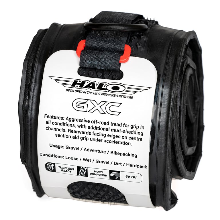 Halo GXC 700c gravel tyre folded and held by a velcro strap with a white paper label, on white.