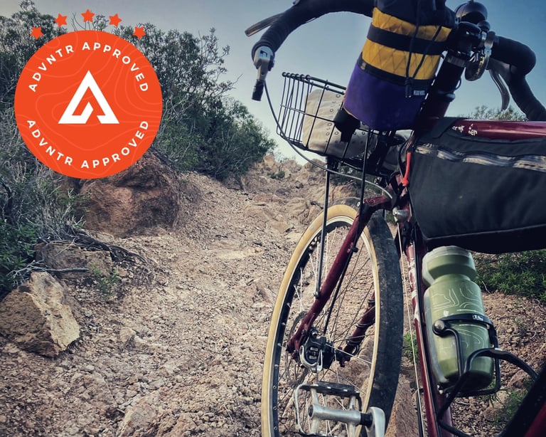 Rene Herse Naches Pass 26-inch tan-wall tyre on a red Surly Disc Trucker with a front basket on a rocky track.