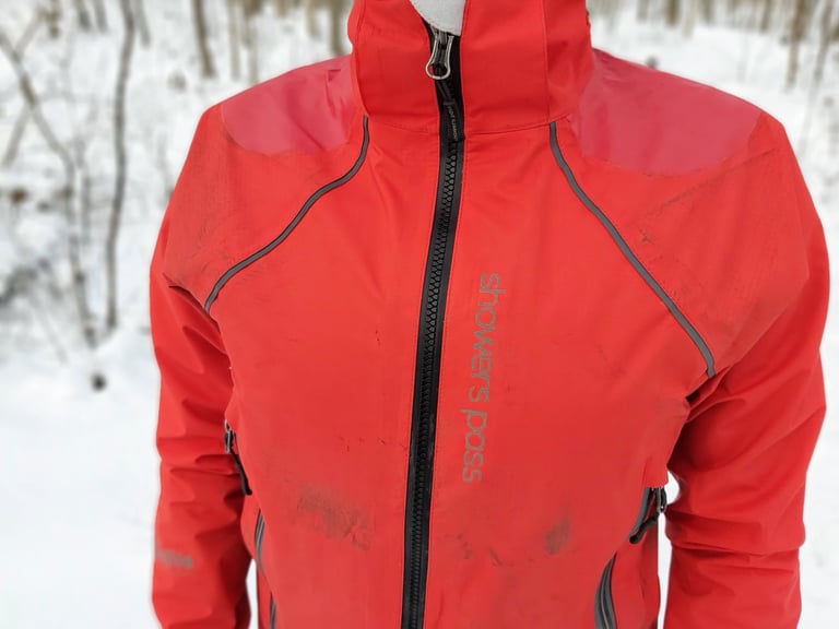 Front of the red Showers Pass Refuge jacket with full-length zip, reflective piping and reinforced shoulders.