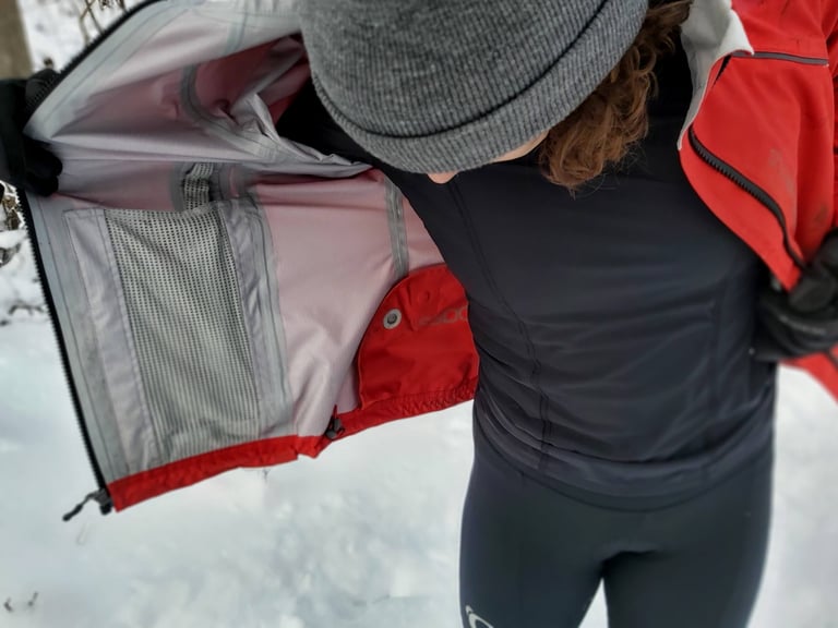 Inside of the open Showers Pass Refuge jacket showing taped seams, mesh pocket and liner.