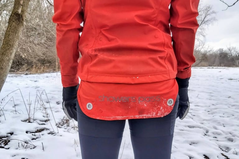 Fold-down rear flap of the Showers Pass Refuge jacket pulled down, with its magnetic fixings, on a snowy trail.