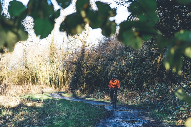 Rider in an orange jacket on a muddy winter track, testing the Rosé Robusto tyres in the UK.