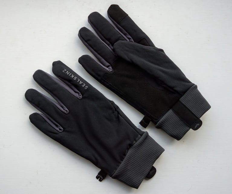 Sealskinz All Weather Lightweight gloves laid flat, one back up and one palm up, showing the suede pad and grey cuffs.