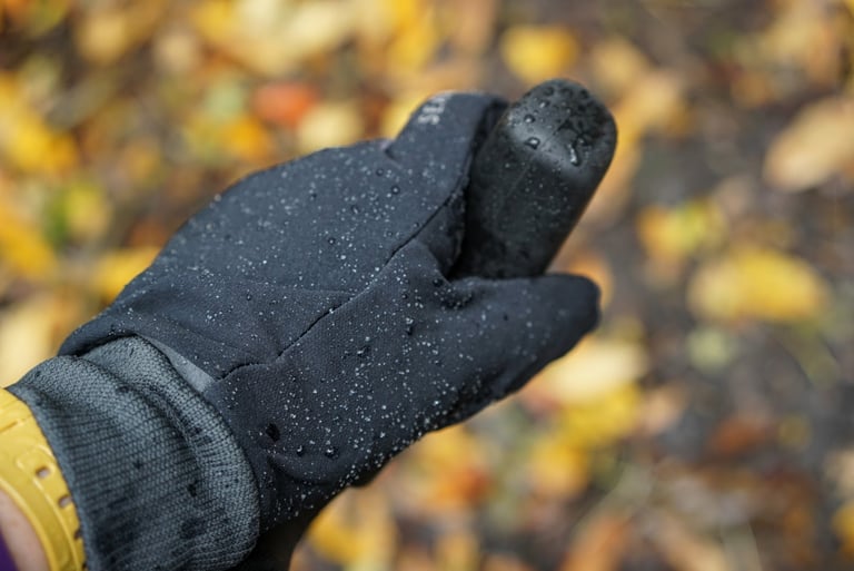 Water droplets bead on the black Lycra outer of a Sealskinz Fusion Control glove in light rain.