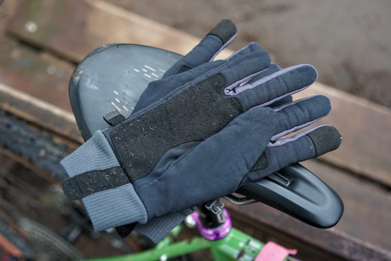 Sealskinz Fusion Control gloves resting on a bike saddle, with light bobbling on the synthetic suede palm pad.