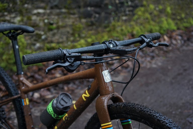 Cockpit of the Marin DSX 2 with flat bars, own-brand grips, brake levers and a Wahoo bike computer.